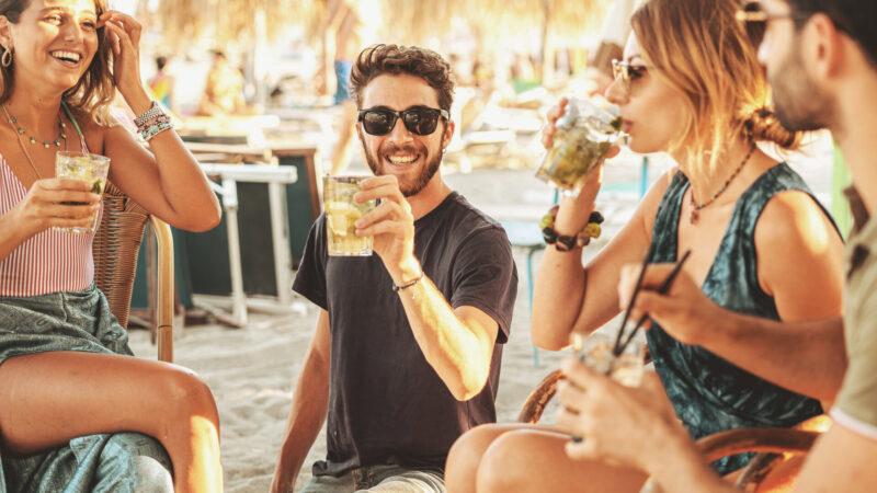 Gruppe junger Freunde, die draußen am Strand feiern