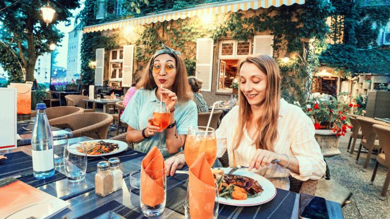 Zwei Freundinnen, die draußen im Garten zu Mittag essen