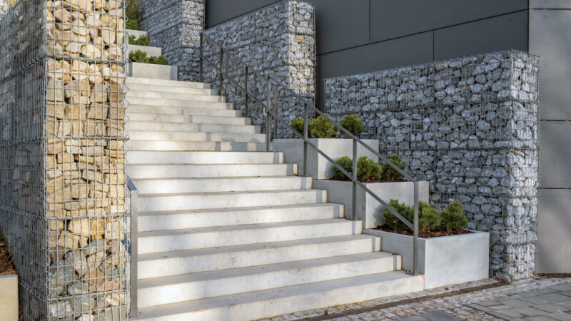 Moderne Treppe aus Beton mit Gabionenzäunen als Blickfang