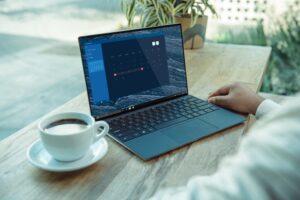 Person nutzt MacBook in der Freizeit bei einer Tasse Kaffee