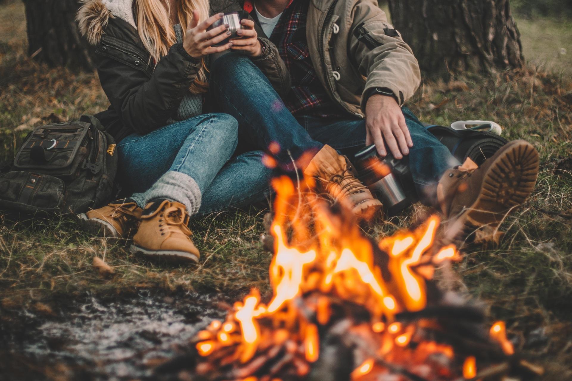 Paar genießt Kaffee am Lagerfeuer beim Camping | Elfliq Liquid